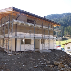 Holzhaus im Rohbau auf einem Hügel.