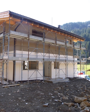 Holzhaus im Rohbau auf einem Hügel.