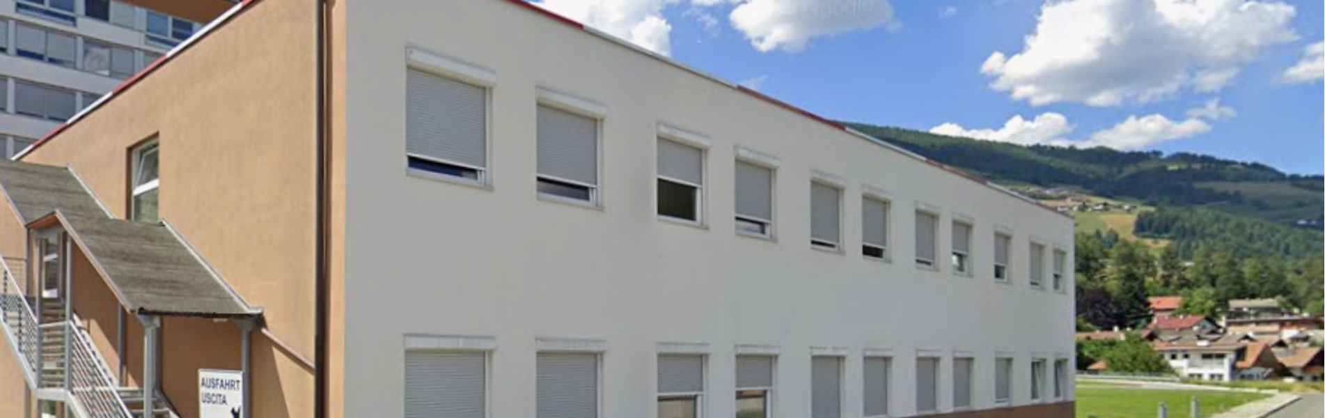 Krankenhausgebäude mit weißer und roter Fassade.