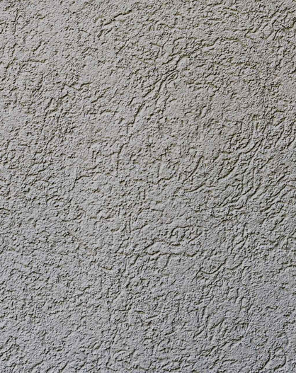 Nahaufnahme einer grauen Wand mit rauer Putzstruktur.