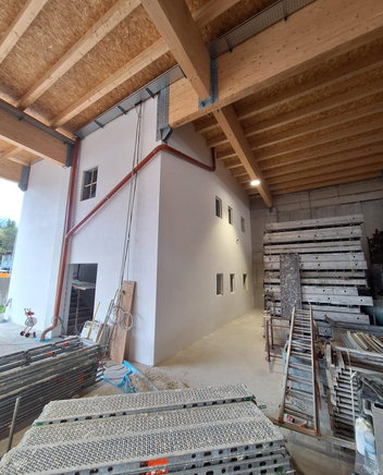 Rohbau mit Holzbalkendecke und Gerüst.